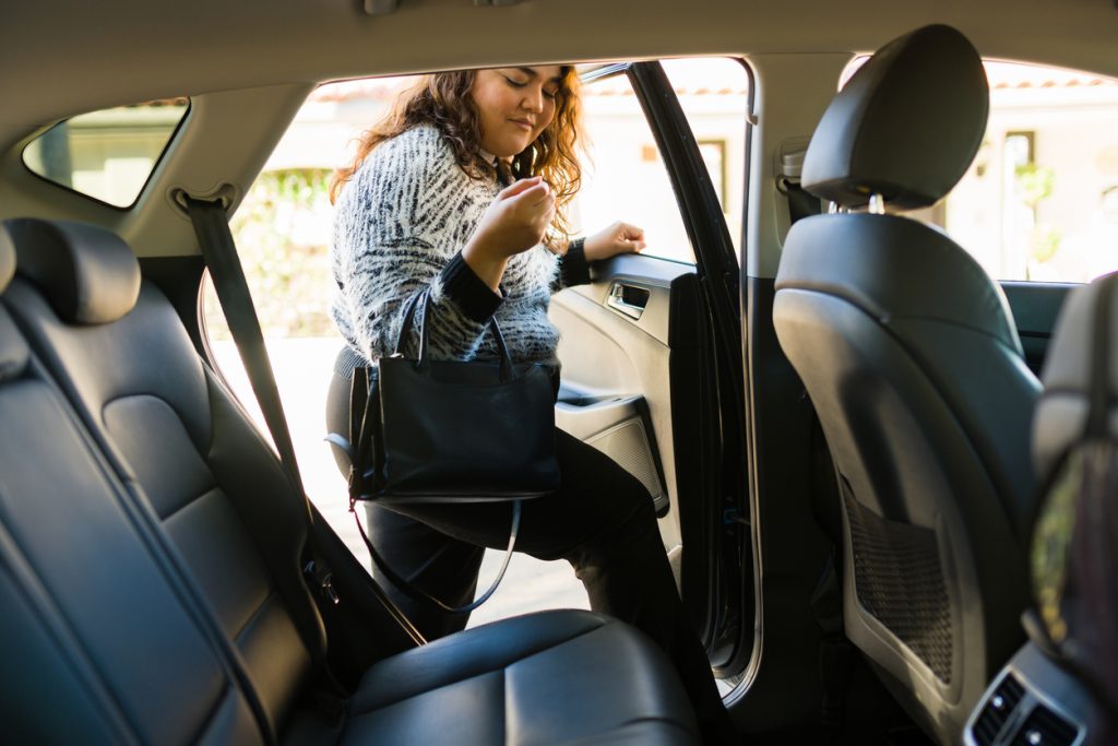 Latin woman requesting a rideshare service car