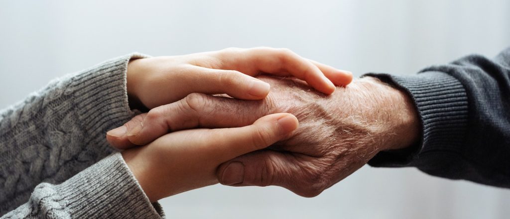 Young lady holding elder gentleman's hand